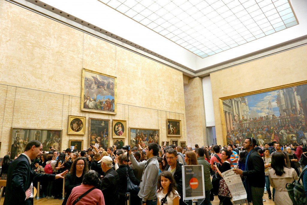 A crowd of people taking a picture of the Mona Lisa