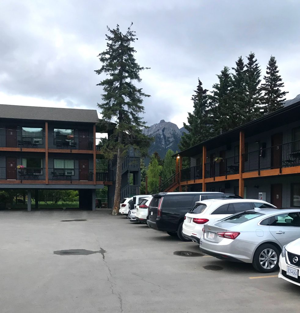 The Lamphouse Hotel in Canmore has a u-shaped layout with a parking lot in the center making it more of a motel. You can see the beautiful mountains of Banff in the background.